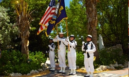 A military color guard in front of palm trees