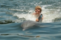 Young mad being towed by a dolphin